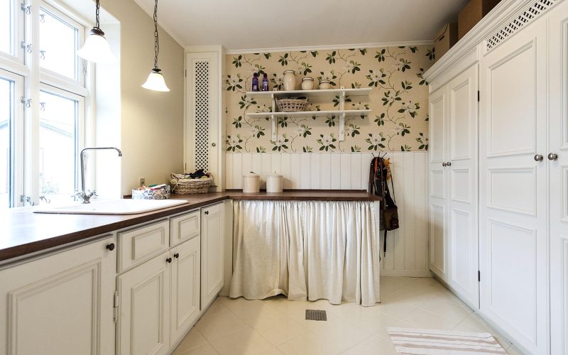 Witte kinderkast in een lichte kinderkamer met speelgoed op de vloer