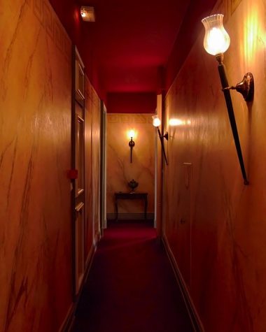 Smalle gang met wandarmaturen die zachte verlichting geven langs de muren